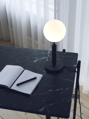 Настольная лампа Nuura Miira Table Opal на черном столе