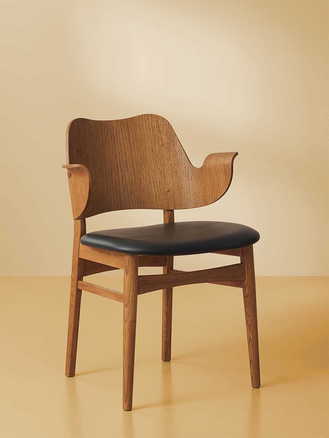 Обеденный стул Warm Nordic Gesture с сидением из черной кожи на бежевом фоне
