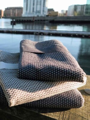 Три полотенца для тела TheOrganic, 155х60см на фоне городского пейзажа