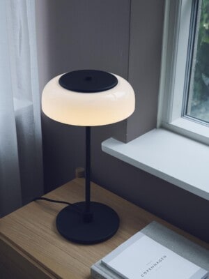 Настольная лампа Nuura Blossi Table черного цвета на столе