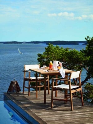 Два обеденных кресла и стол Skargaarden Djurö на террасе у бассейна с видом на море