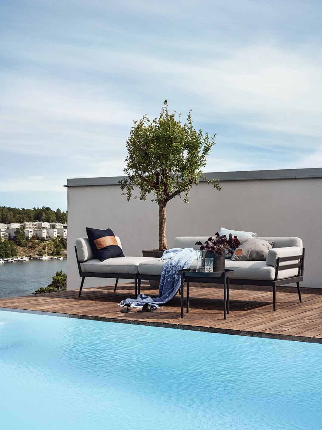 Совмещенные дизайнерские кресло для отдыха и диван Skargaarden Anholt на террасе у бассейна