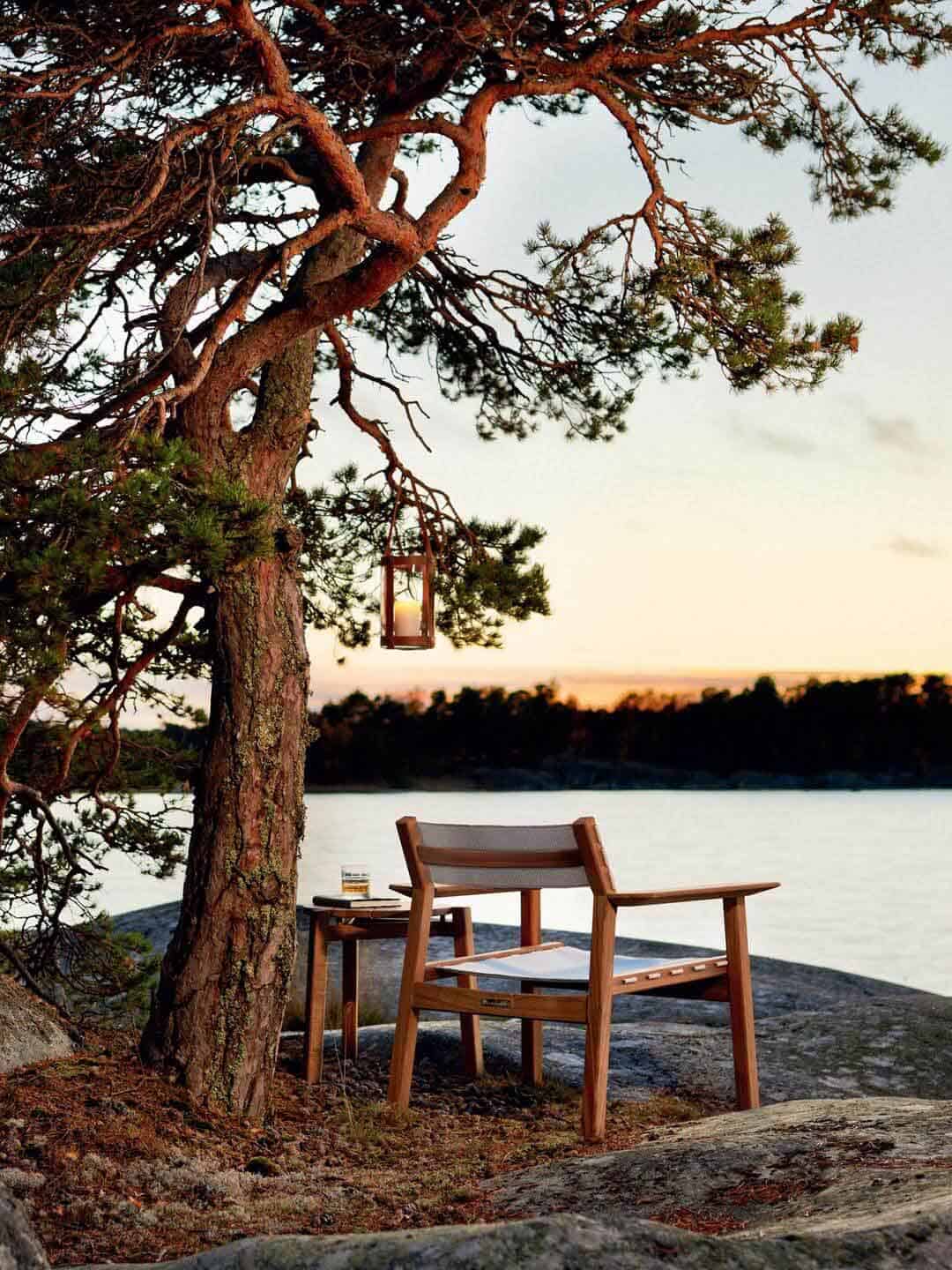 Кресло для отдыха и кофейный стол Skargaarden Djurö под деревом на берегу озера