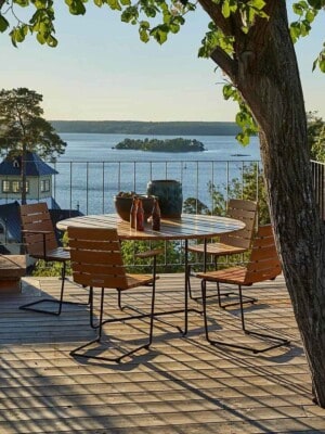 Кресло, стол и стулья Skargaarden Grinda на балконе с видом на воду