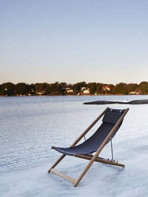 Элитное кресло-шезлонг для отдыха Skargaarden H55 на открытой веранде с видом на реку