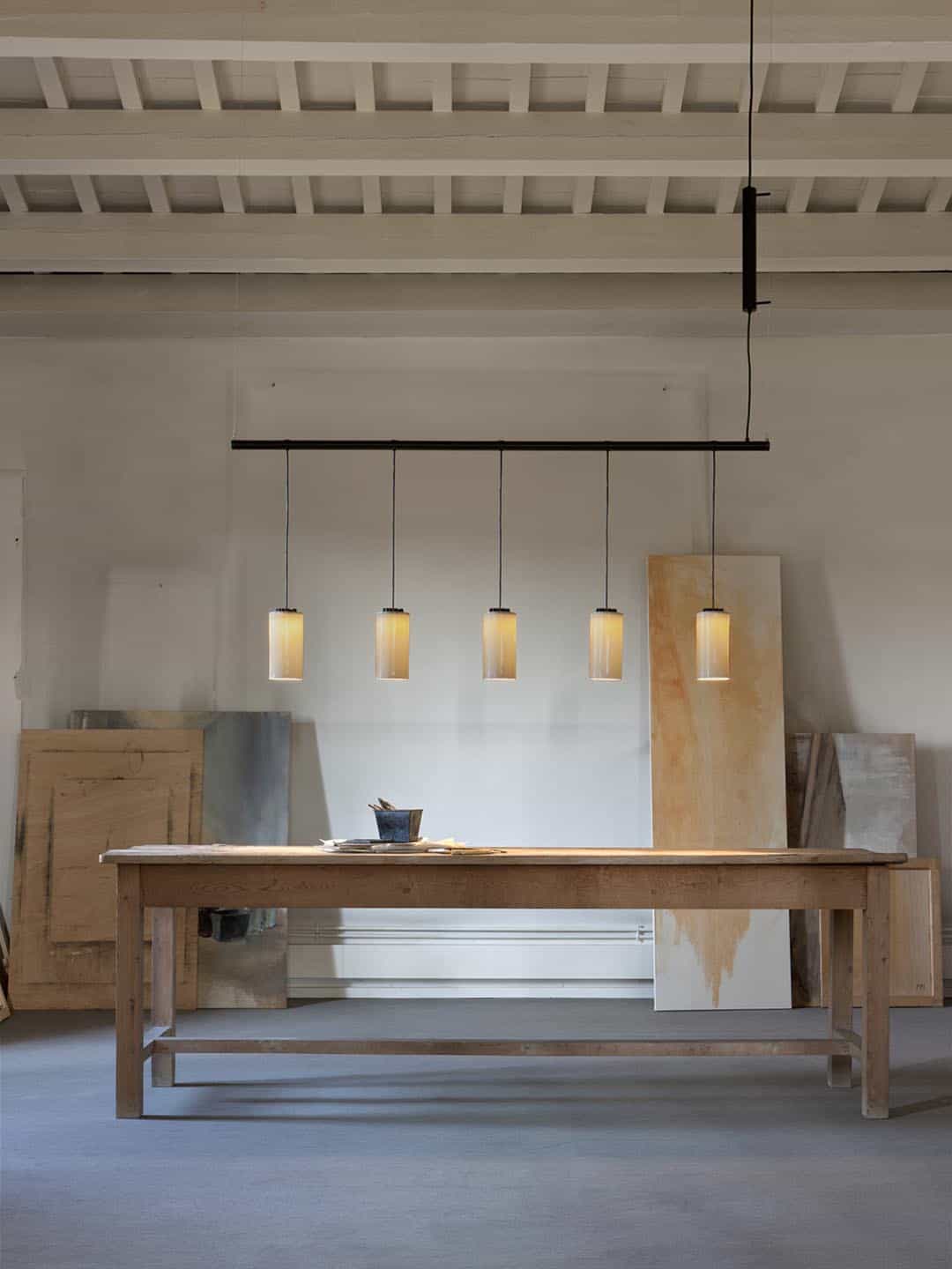 Дизайнерский подвесной светильник Santa Cole Cirio Lineal 5 белый фарфор над рабочим столом в мастерской